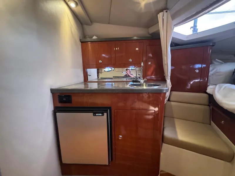 Slide: The Image of 2011 Regal 35 Express Cruiser interior with kitchenette and seating area. - 36