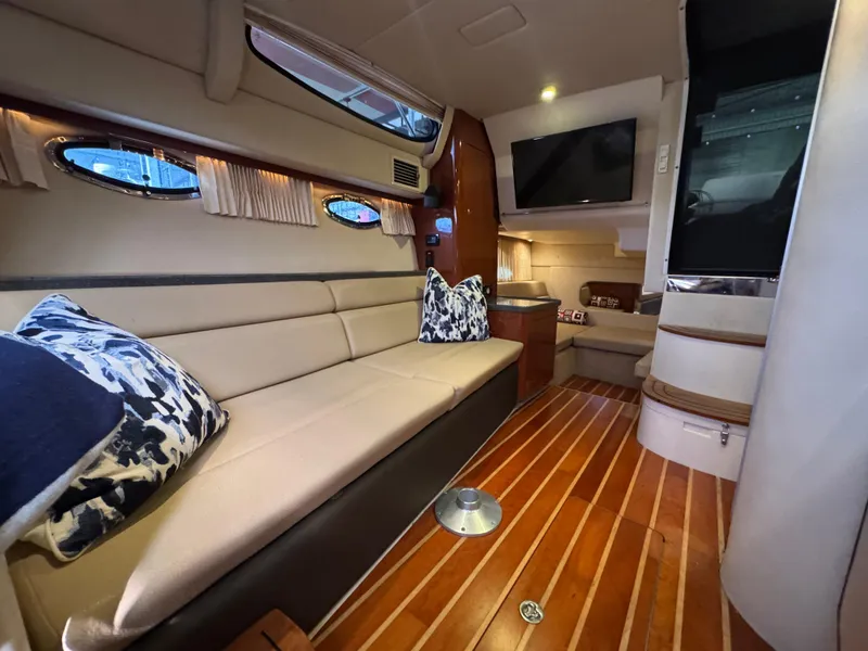 Slide: The Image of Interior of 2011 Regal 35 Express Cruiser with beige seating and wood flooring. - 38