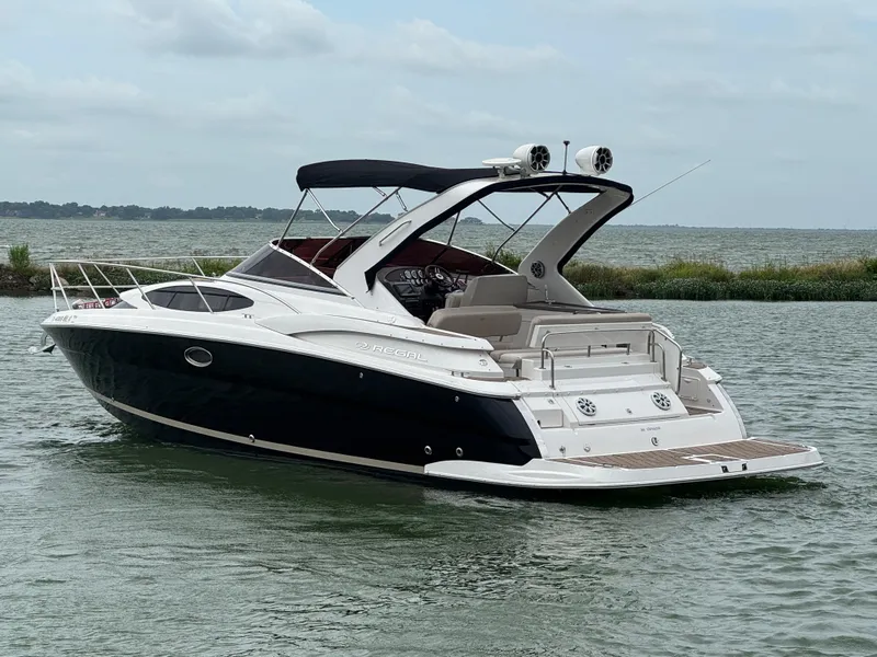 Slide: The Image of 2011 Regal 35 Express Cruiser on calm water, featuring sleek design and spacious deck. - 9