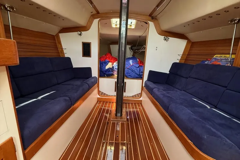 Slide: The Image of Interior of 2005 J Boats J/124 sailboat with blue seating and wooden flooring. - 15