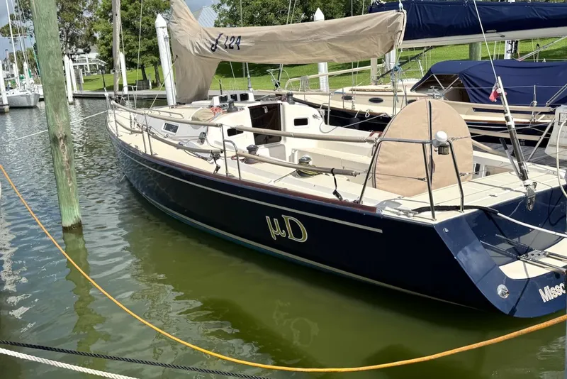 Slide: The Image of 2005 J Boats J/124 sailboat docked in marina, featuring sleek design and beige sail cover. - 6