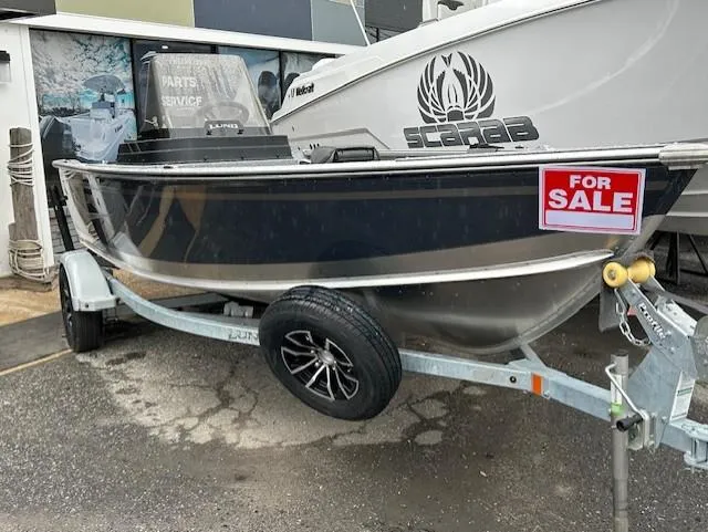 Slide: The Image of 2025 Lund 1675 Alaskan SS boat for sale on trailer, parked outdoors. - 2