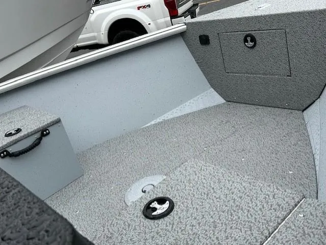 Slide: The Image of 2025 Lund 1675 Alaskan SS boat interior with gray textured flooring and storage compartments. - 3