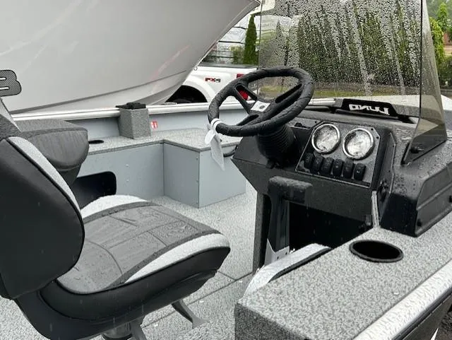 Slide: The Image of 2025 Lund 1675 Alaskan SS boat interior with steering wheel and seating. - 4