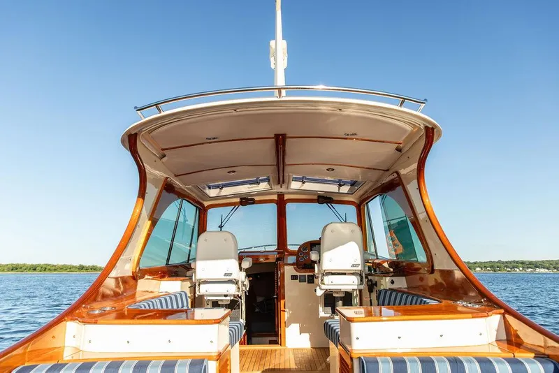 Slide: The Image of 2018 Hinckley Picnic Boat 37 MKIII interior with elegant seating and helm, on calm water. - 1