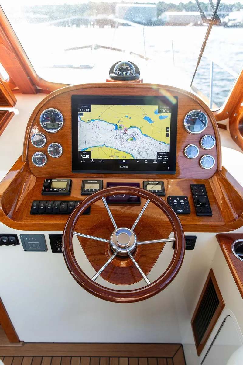 Slide: The Image of Helm of 2018 Hinckley Picnic Boat 37 MKIII with navigation display and wooden steering wheel. - 2