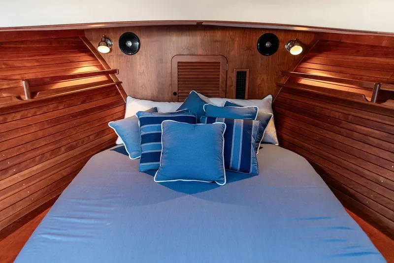 Slide: The Image of Cozy cabin interior of 2018 Hinckley Picnic Boat 37 MKIII with blue bedding and wooden paneling. - 3