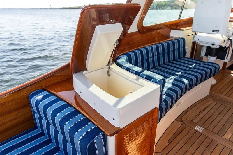 Slide: The Image of 2018 Hinckley Picnic Boat 37 MKIII interior with blue striped seating and open storage compartment. - 31