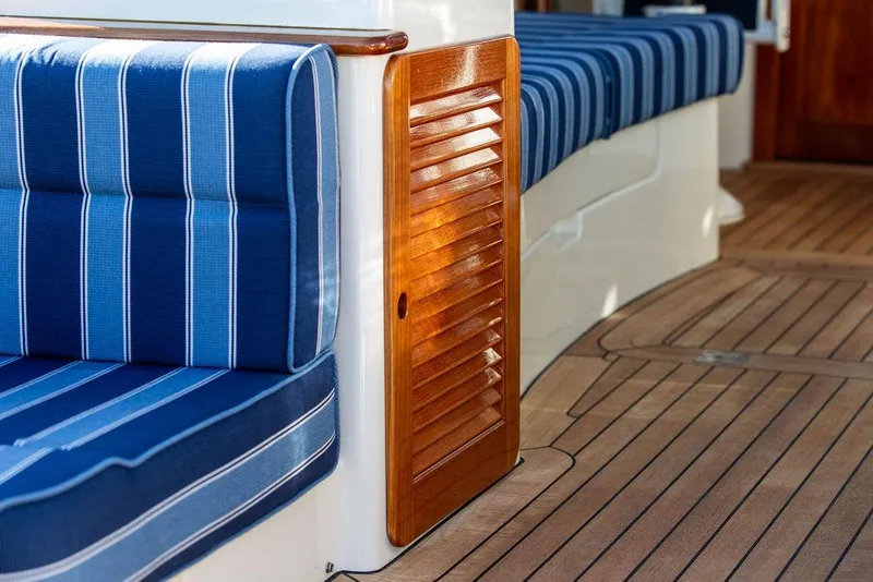 Slide: The Image of Hinckley Picnic Boat 37 MKIII 2018 interior with blue striped seating and wooden accents. - 32