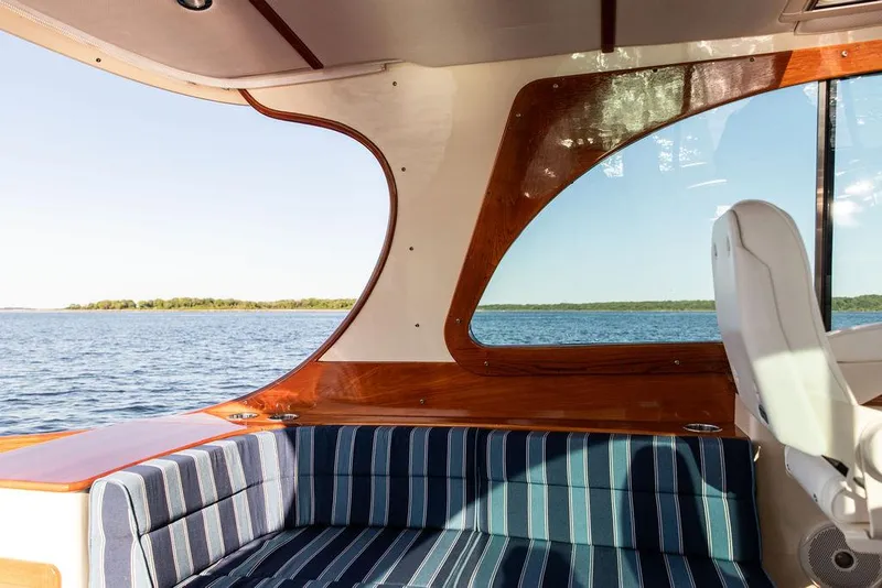 Slide: The Image of Interior view of 2018 Hinckley Picnic Boat 37 MKIII with striped seating and scenic water backdrop. - 35