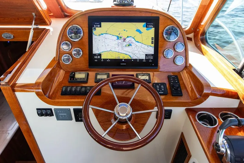 Slide: The Image of Helm of 2018 Hinckley Picnic Boat 37 MKIII with navigation display and wooden steering wheel. - 37