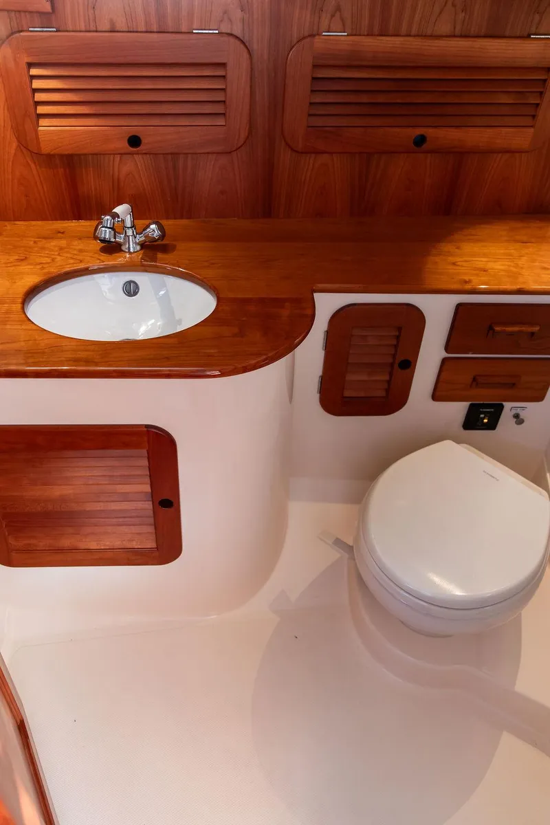 Slide: The Image of 2018 Hinckley Picnic Boat 37 MKIII bathroom with wooden cabinetry and modern fixtures. - 4