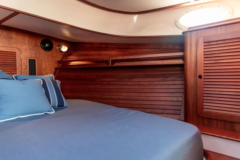 Slide: The Image of 2018 Hinckley Picnic Boat 37 MKIII cabin with wooden interior and blue bedding. - 44