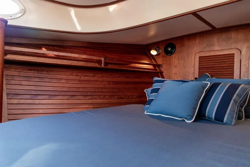 Slide: The Image of Cabin interior of 2018 Hinckley Picnic Boat 37 MKIII with blue bedding and wooden paneling. - 45