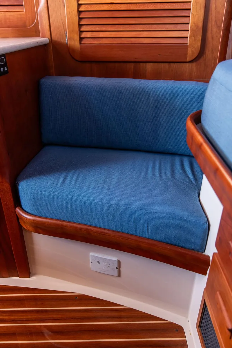 Slide: The Image of 2018 Hinckley Picnic Boat 37 MKIII interior with blue cushioned seating and wooden accents. - 48