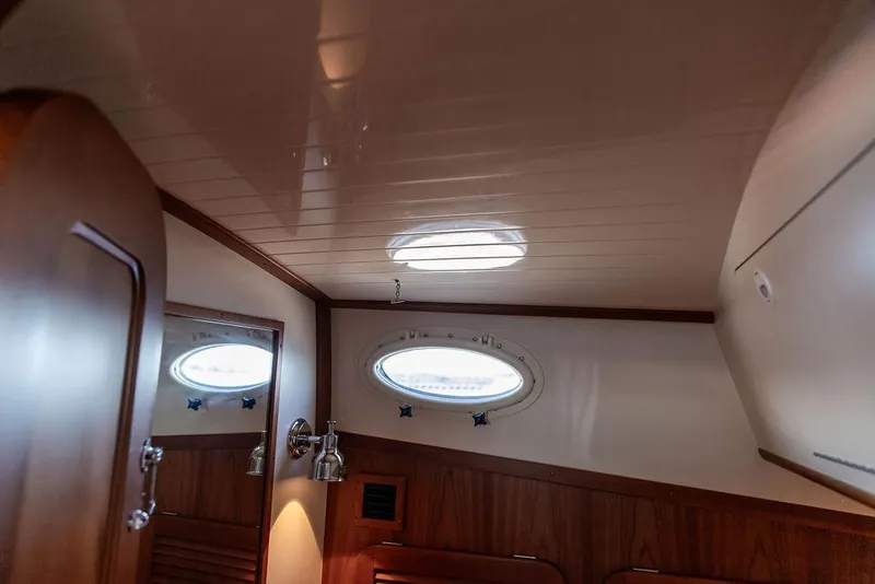 Slide: The Image of Interior of 2018 Hinckley Picnic Boat 37 MKIII with wooden paneling and porthole window. - 49