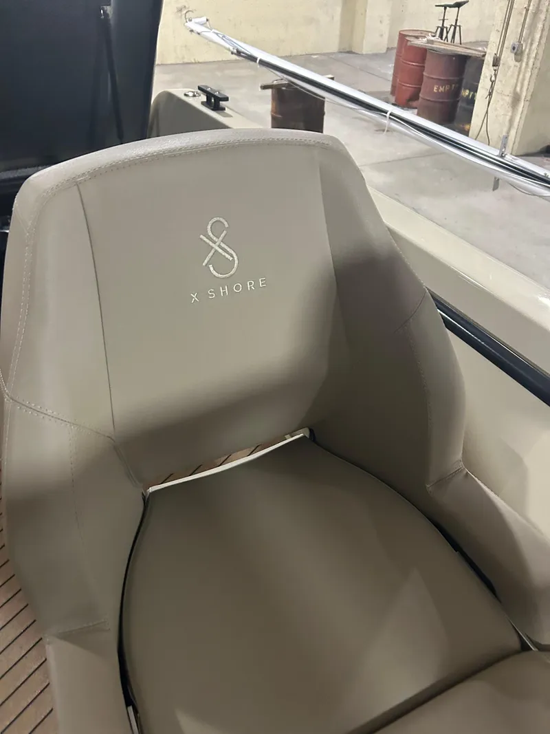 Slide: The Image of 2024 X Shore 1 boat seat with logo in a garage setting. - 10