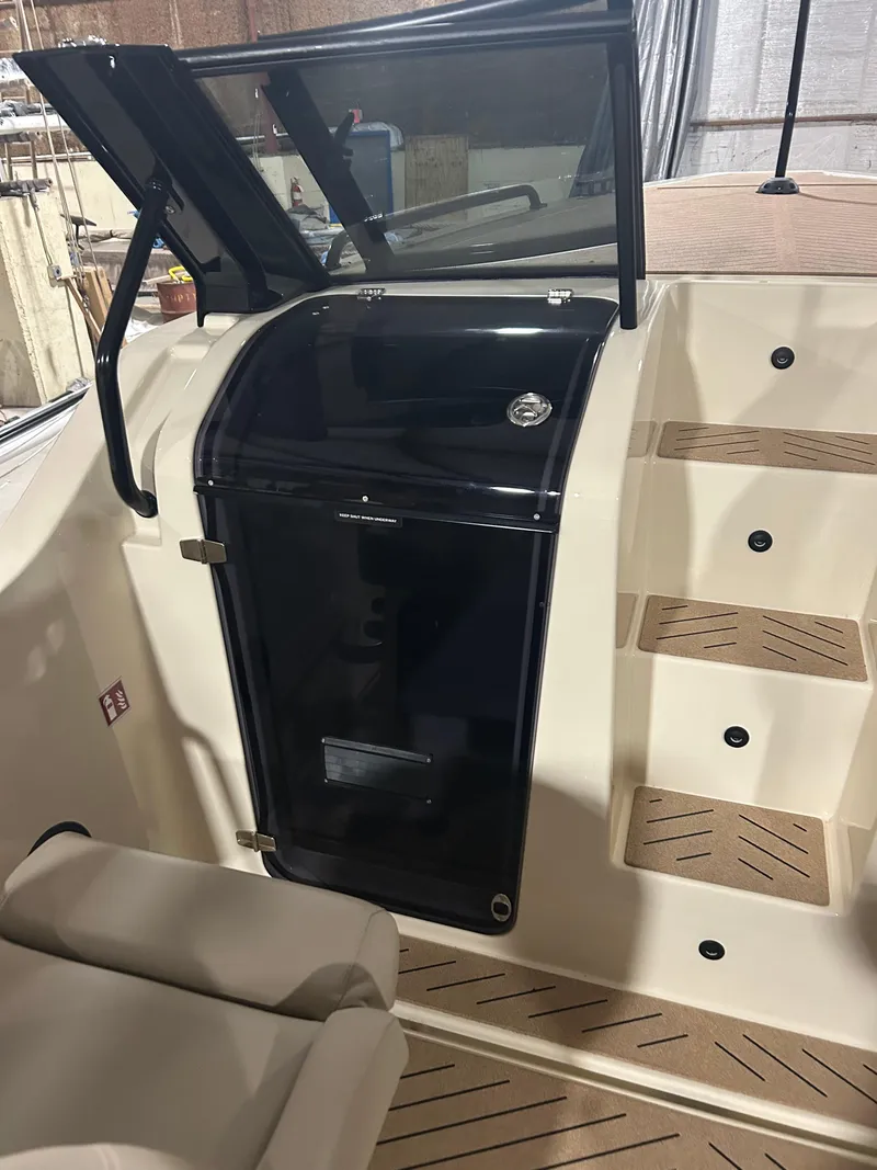 Slide: The Image of 2024 X Shore 1 boat interior with sleek black console and wooden steps. - 14