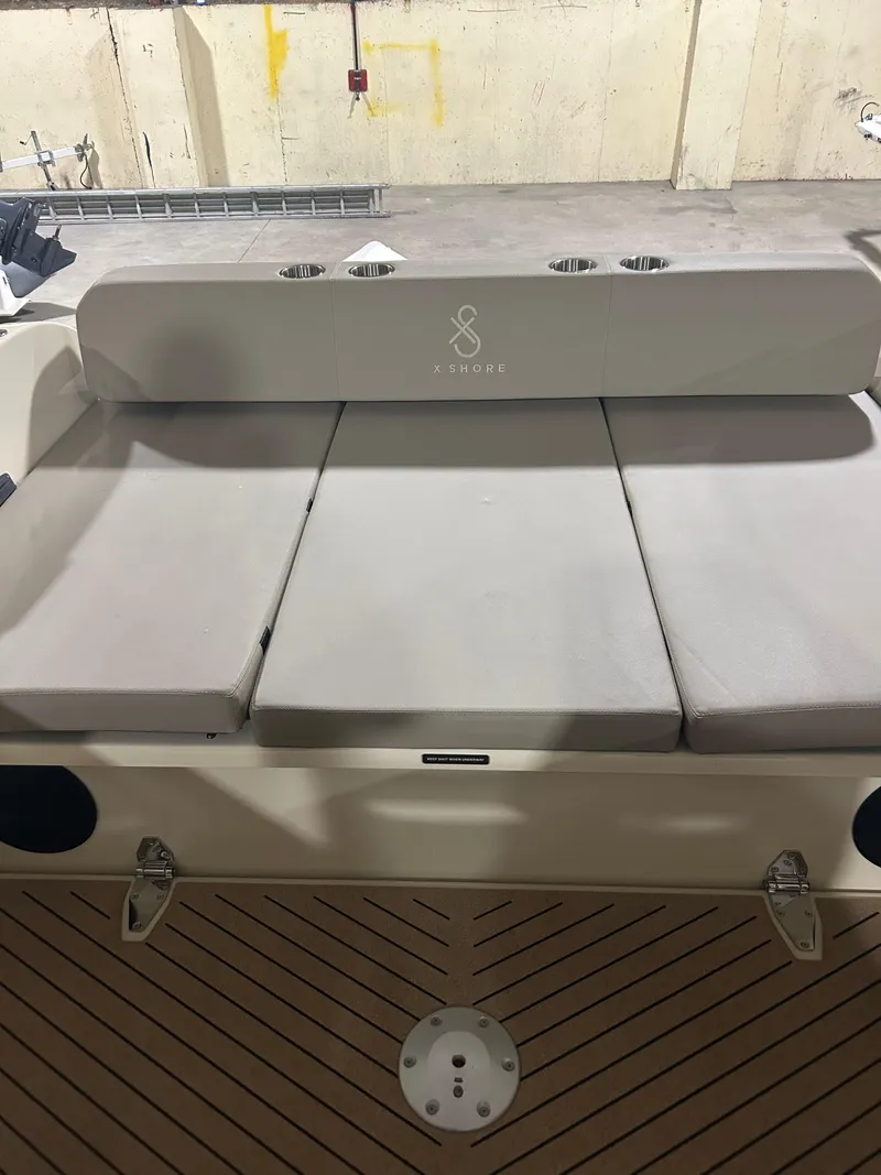 Slide: The Image of 2024 X Shore 1 boat interior with cushioned seating and modern design. - 18