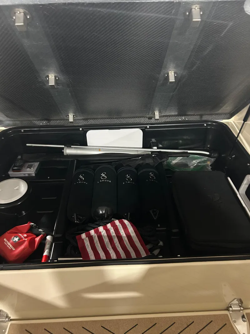 Slide: The Image of Open storage compartment of 2024 X Shore 1, containing various items and accessories. - 19