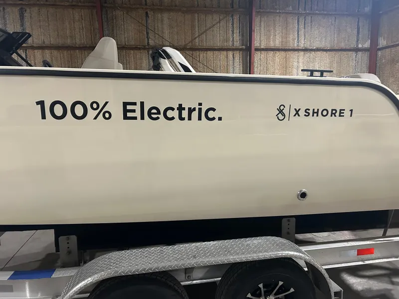 Slide: The Image of 2024 X Shore 1 electric boat on trailer, showcasing "100% Electric" branding. - 2