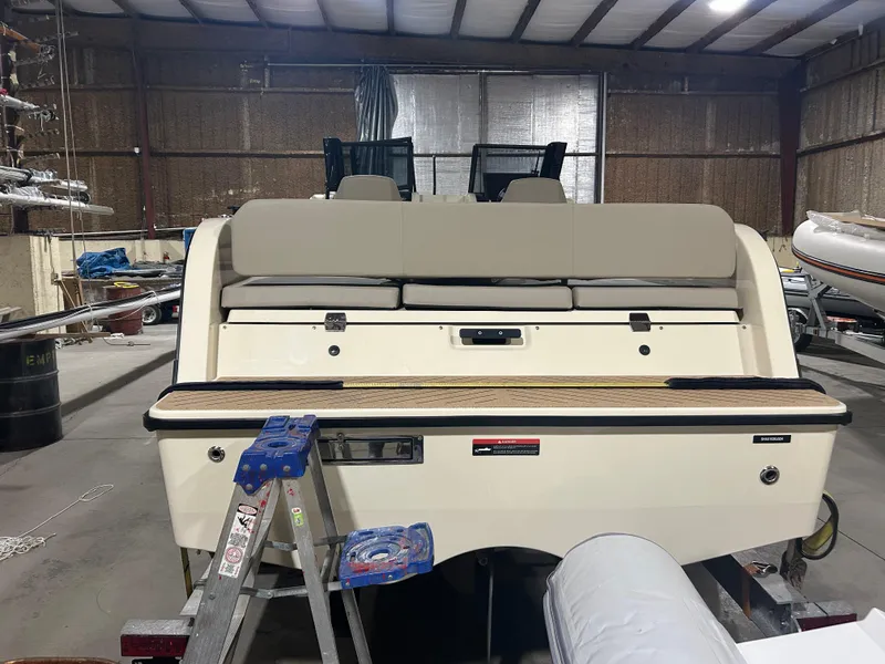 Slide: The Image of 2024 X Shore 1 electric boat in a warehouse, rear view with seating and ladder. - 4