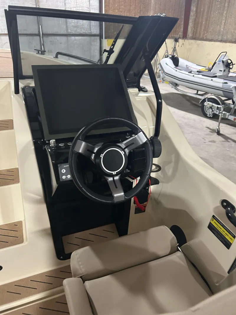 Slide: The Image of 2024 X Shore 1 boat interior with steering wheel and control panel in a garage setting. - 8