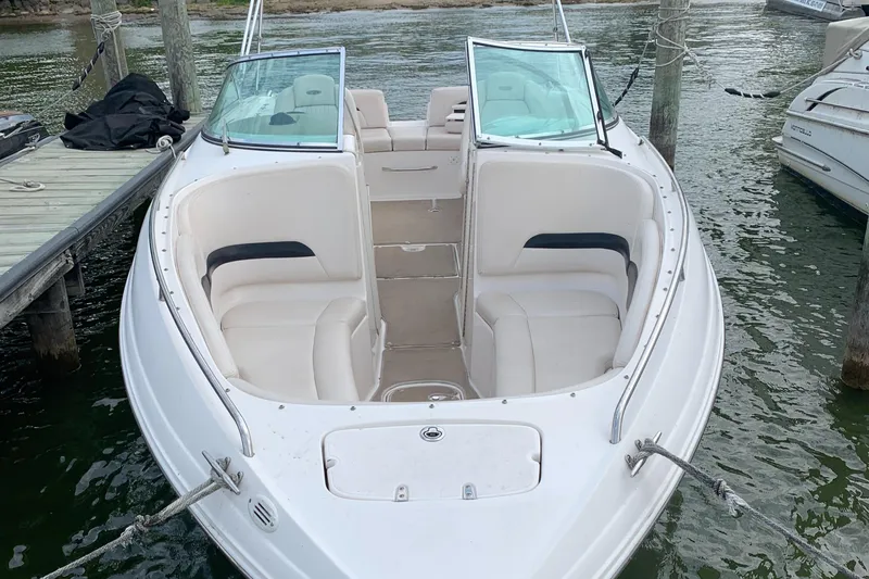 Slide: The Image of 2003 Chaparral 260 SSi boat docked, featuring spacious seating and sleek design. - 2