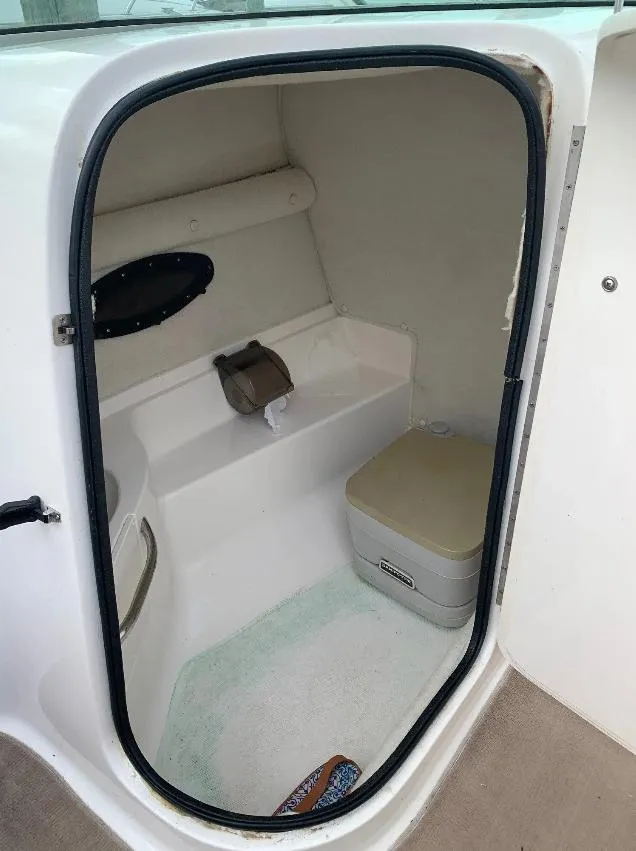 Slide: The Image of 2003 Chaparral 260 SSi boat interior with compact restroom and portable toilet. - 4