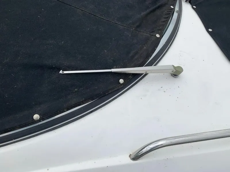 Slide: The Image of 2003 Chaparral 260 SSi boat with black cover and metal railing. - 5