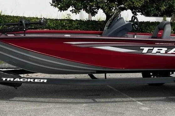 Slide: The Image of 2025 Tracker Pro Team 195 Tournament Edition boat, red and gray design, parked on trailer. - 87