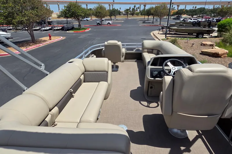 Slide: The Image of 2025 Sun Tracker SportFish 20 DLX pontoon boat interior with beige seating and steering console. - 14