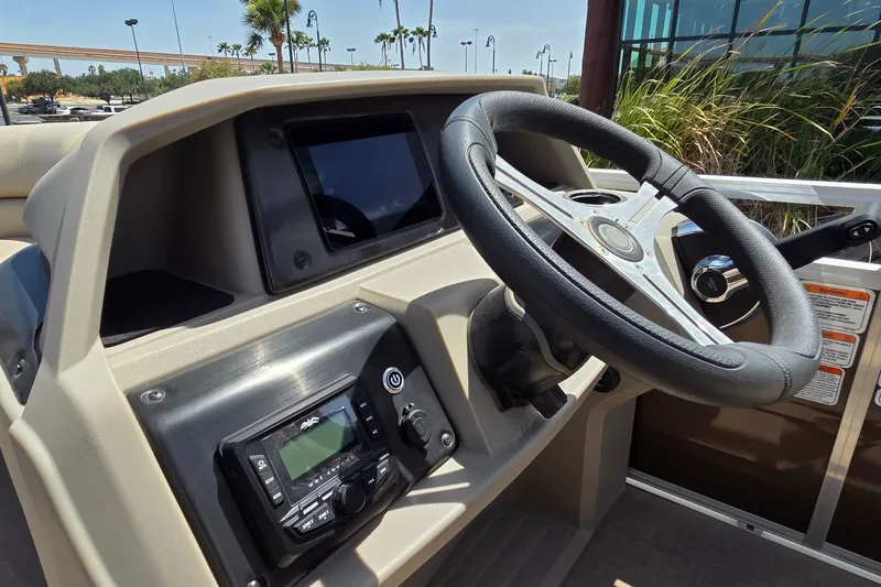 Slide: The Image of 2025 Sun Tracker SportFish 20 DLX boat dashboard with steering wheel and control panel. - 19