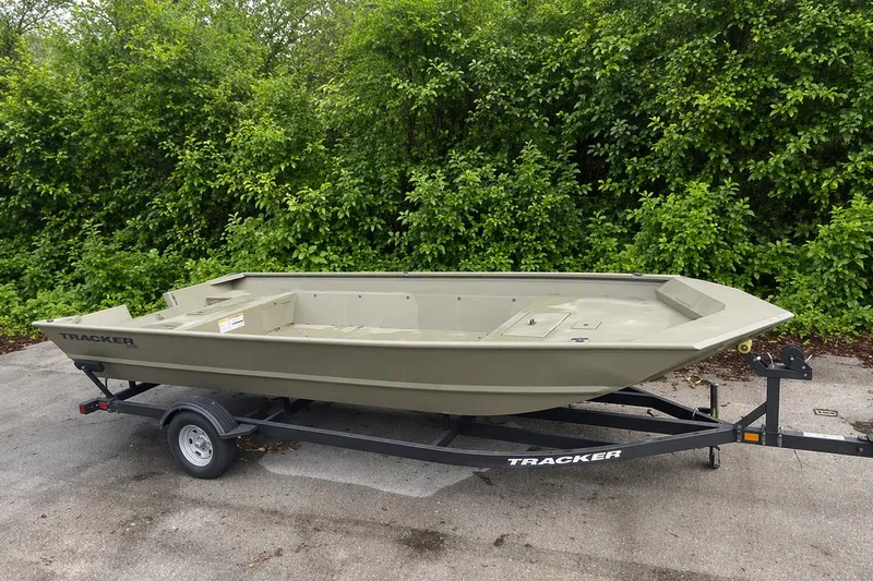 The Image of 2025 Tracker Grizzly 2072 Utility boat on trailer, parked outdoors with greenery background. - 0