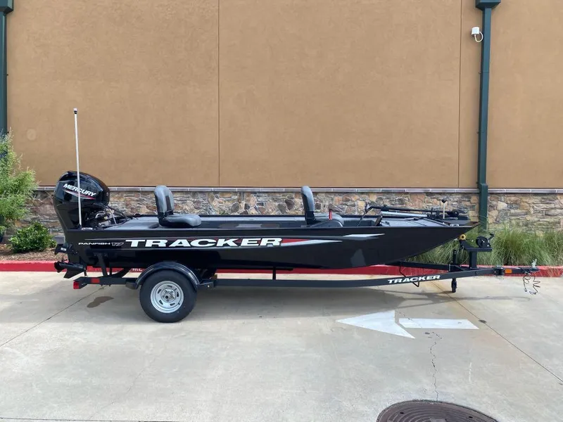Slide: The Image of 2025 Tracker Panfish 17 boat on trailer, parked outdoors, side view. - 2