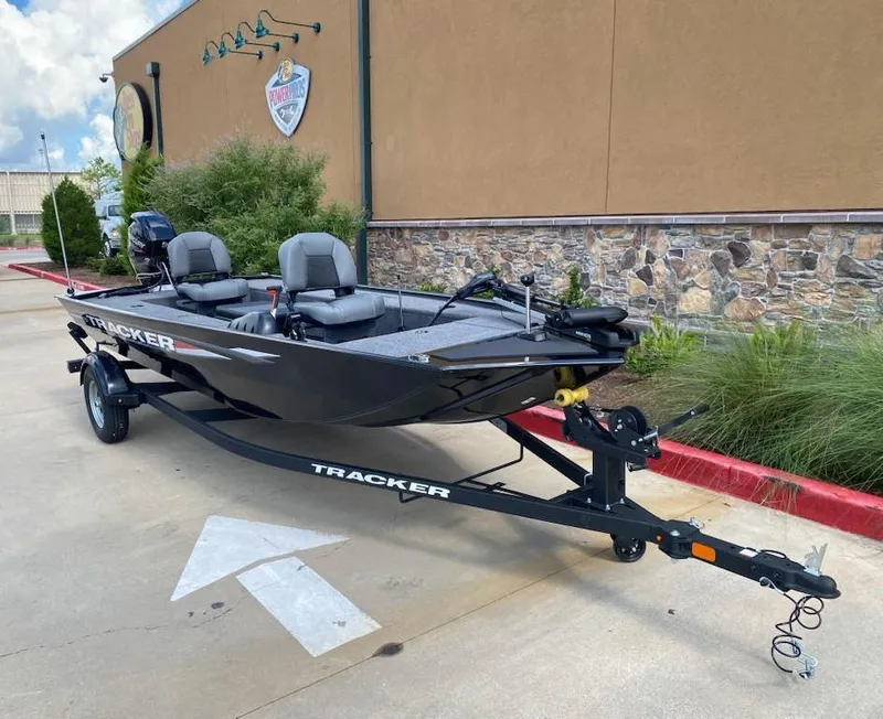 Slide: The Image of 2025 Tracker Panfish 17 boat on trailer, parked outdoors near a building. - 3