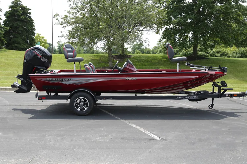 Slide: The Image of 2025 Ranger RT188 boat in red, parked on a trailer in a scenic outdoor setting. - 1