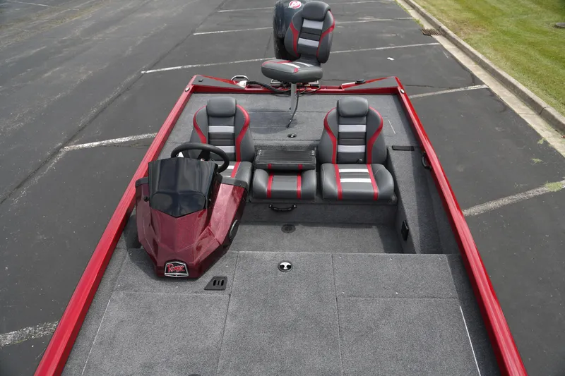Slide: The Image of 2025 Ranger RT188 boat interior with red and gray seating, parked on asphalt. - 3