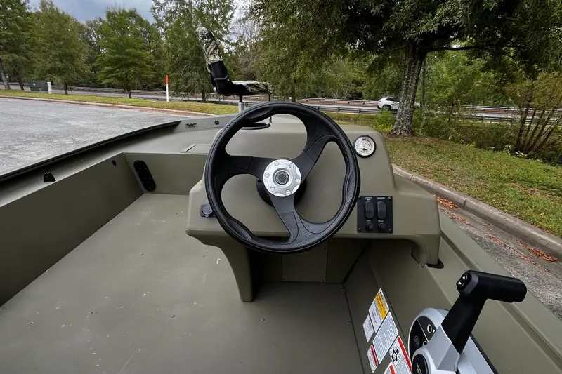 Slide: The Image of 2025 Tracker Grizzly 1754 SC boat interior with steering wheel and control panel. - 17