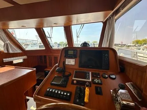 Slide: The Image of 2009 Marine Trader 36 Euro Sedan helm with navigation equipment and marina view. - 34