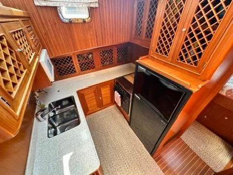 Slide: The Image of 2009 Marine Trader 36 Euro Sedan kitchen with wood cabinetry, dual sink, and compact refrigerator. - 39