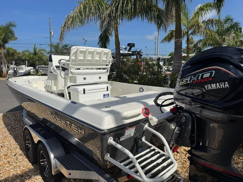 Slide: The Image of 2025 Skeeter SX 230 boat with Yamaha engine, parked outdoors near palm trees. - 11