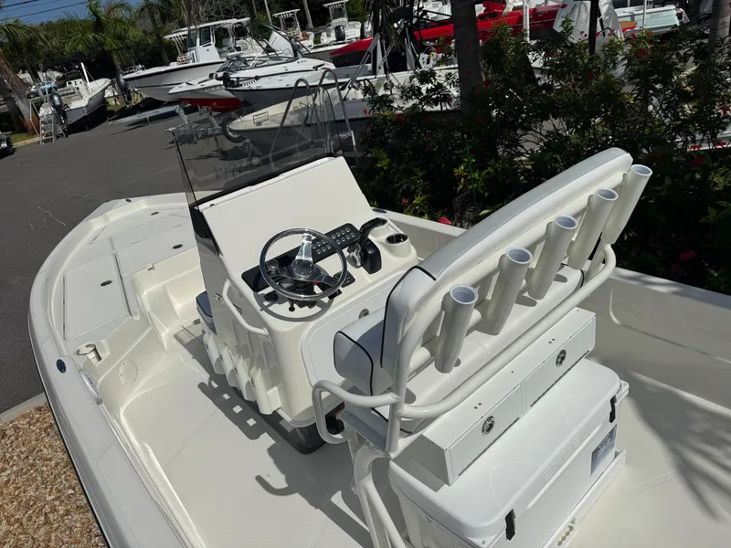Slide: The Image of 2025 Skeeter SX 230 boat with center console and rod holders, parked in a marina. - 15