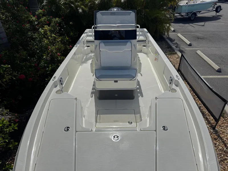 Slide: The Image of 2025 Skeeter SX 230 boat interior with seating and console, parked outdoors. - 22