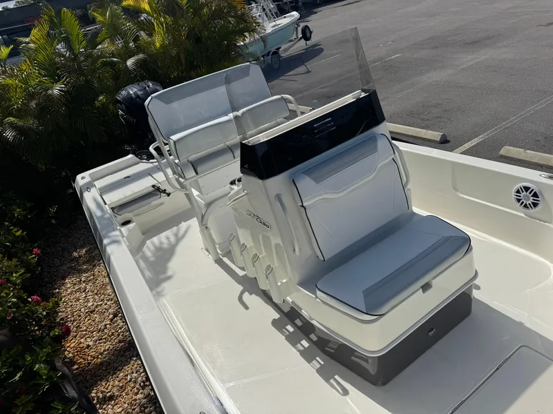 Slide: The Image of 2025 Skeeter SX 230 boat interior with seating and console, parked outdoors. - 23