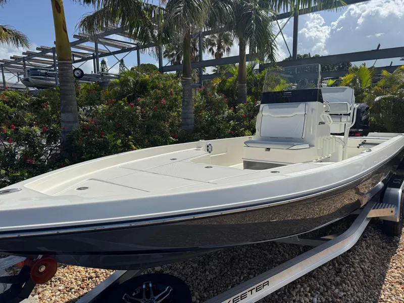 Slide: The Image of 2025 Skeeter SX 230 boat on trailer, surrounded by tropical foliage. - 3