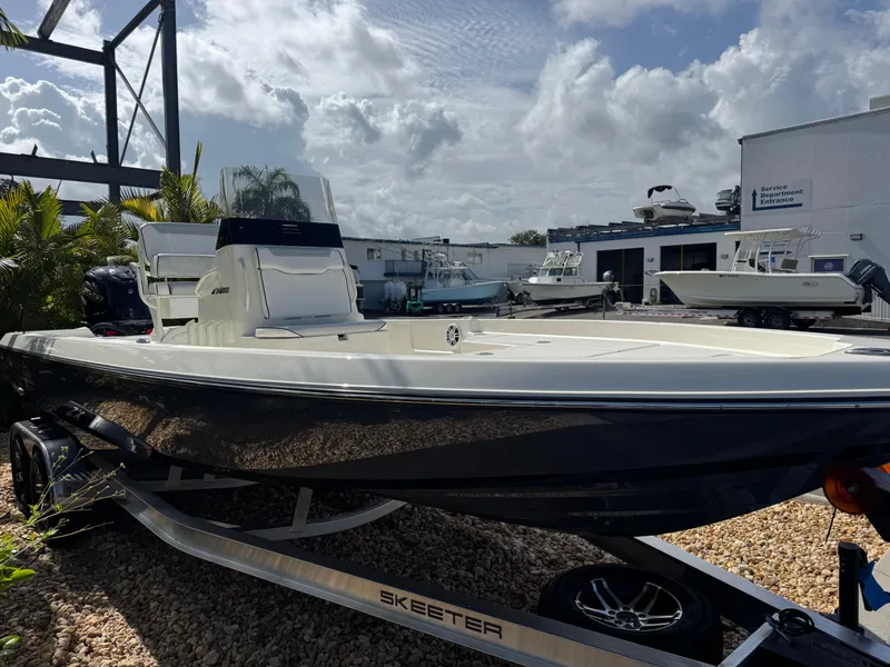 Slide: The Image of 2025 Skeeter SX 230 boat on trailer, parked outdoors under cloudy sky. - 6