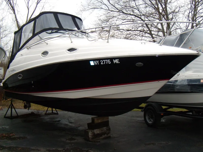 The Image of 2008 Regal Commodore 2665 boat on display, black and white exterior, parked on a trailer. - 0