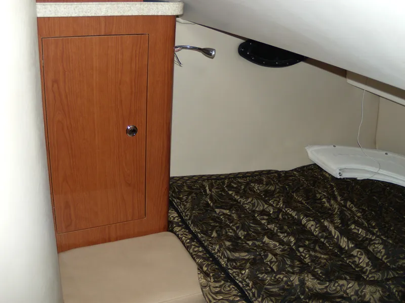 Slide: The Image of 2008 Regal Commodore 2665 cabin interior with wood cabinet and patterned bedding. - 15