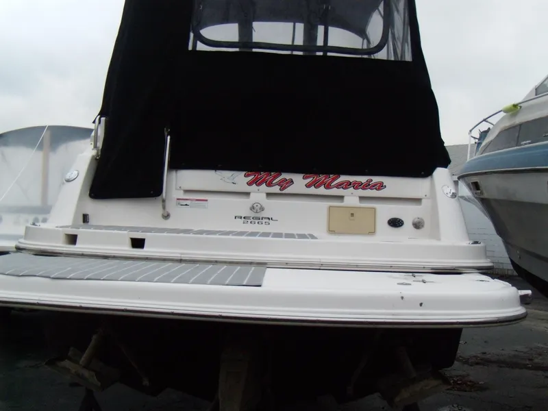 Slide: The Image of 2008 Regal Commodore 2665 boat with black canopy, docked at marina. - 2